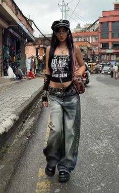 Woman in a black crop top and baggy jeans walking on a street