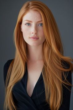 Woman with long red hair and freckles wearing a black top