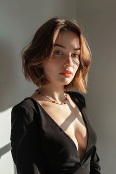 Woman with short hair and a black top with dramatic lighting indoors