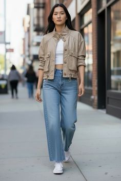 Woman in a cropped jacket and wide leg jeans walking on a city street