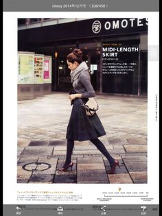 Woman in a plaid midi skirt and scarf walking on a city street