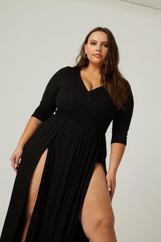 Woman in a black dress with high slits and cleavage in a studio