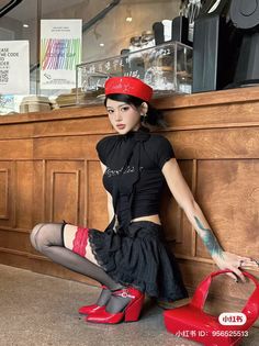 Woman in a red beret and black outfit with red thigh-high stockings posing indoors