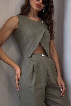 Woman in a green sleeveless top and wide leg pants with sunglasses