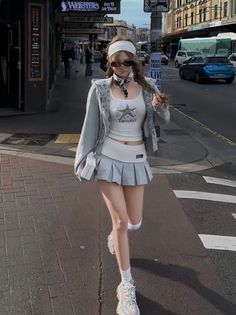 Woman in a pleated skirt and crop top walking on a city street