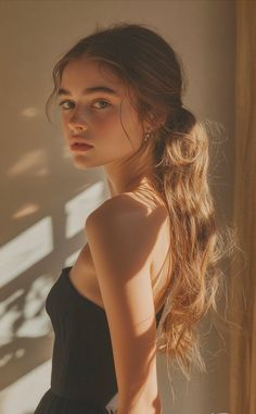 Woman with long hair in a black dress, lit by golden hour sunlight