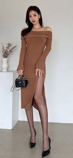 Woman in a brown off-shoulder dress with a high slit and black tights