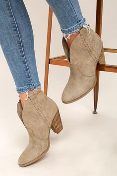 Person wearing blue jeans and light brown suede ankle boots