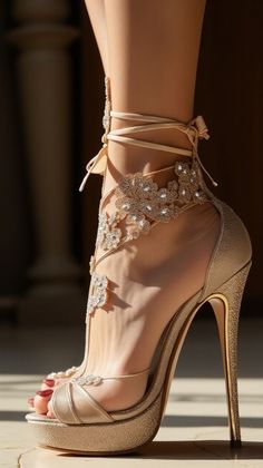 Close up of a foot in gold lace-up high heels with rhinestone embellishments