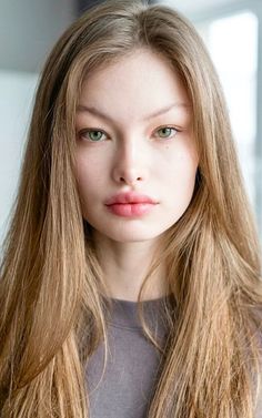 Woman with long blonde hair and green eyes in a soft lighting portrait