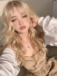 Blonde woman with green eyes and an off-shoulder top in soft lighting