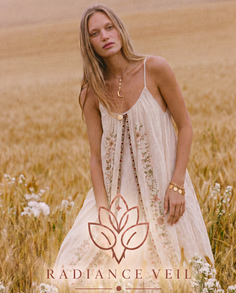 Woman with long blonde hair in a white embroidered dress in a wheat field