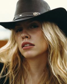 Blonde woman wearing a cowboy hat in a close-up portrait