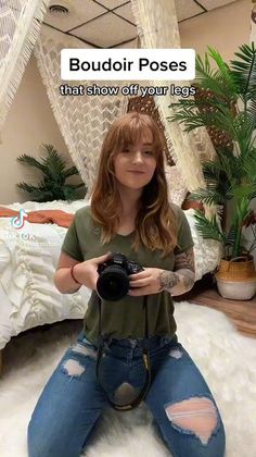 Woman with long hair and ripped jeans holding a camera in a bedroom