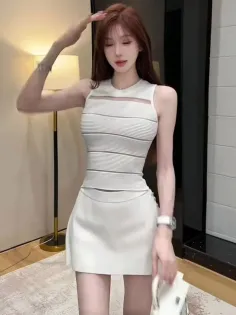 Woman with long hair wearing a white top and mini skirt indoors
