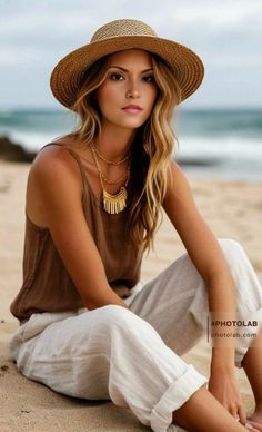 Woman in a straw hat and brown tank top sitting on a beach