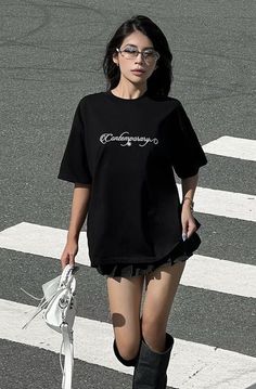 Woman in a black t-shirt and mini skirt walking on a crosswalk