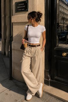 Woman in a white crop top and wide leg pants on a sunny street