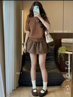 Woman in a brown top and shorts with mary jane shoes and white socks