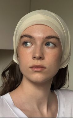 Woman with a head scarf and blue eyes looking to the side