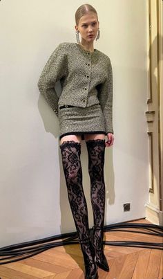 Woman in a tweed suit and lace stockings posing indoors