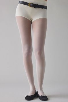 Person wearing white tights, high-waisted shorts, and black flats