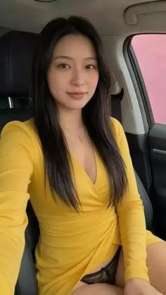 Woman in a yellow dress and black underwear sitting in a car