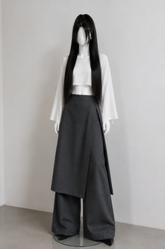Mannequin wearing a white crop top, dark wide leg pants, and a wrap skirt