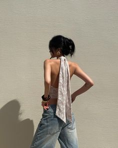 Woman in a halter top and denim jeans with her back to the camera