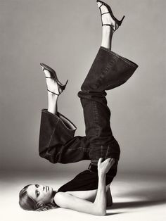 Woman in jeans and high heels in a dynamic pose on a studio floor