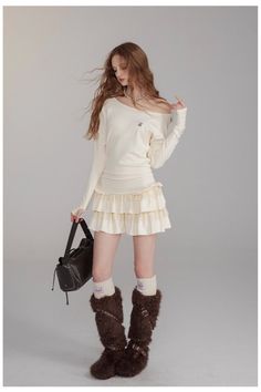 Woman with long hair wearing a ruffled skirt and furry boots in a studio