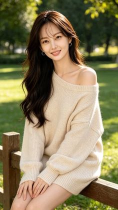 Woman with long hair wearing an off-shoulder sweater outdoors