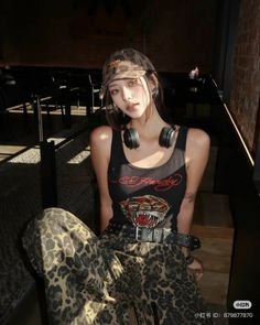 Woman in leopard print clothing and a tank top with headphones around her neck
