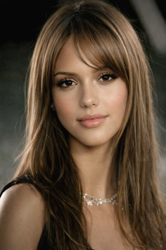 Woman with long brown hair and bangs wearing a necklace