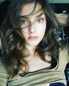Woman with long wavy hair and green eyes looking directly at the camera