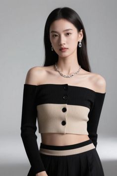 Woman with long black hair wearing an off-shoulder crop top and jewelry in a studio