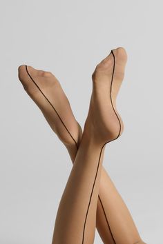 Legs wearing seamed stockings against a light background