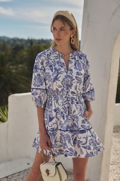 Woman in a blue and white patterned dress with a headband outdoors