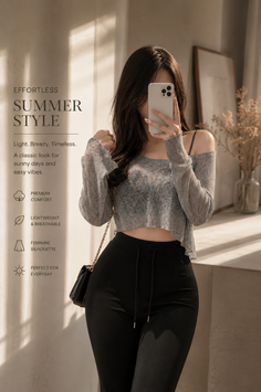 Woman taking a mirror selfie in a gray crop top and black pants