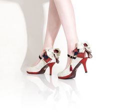 Pair of high heels with decorative bows and ankle straps on a white reflective surface