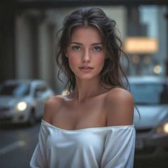 Woman with long hair wearing an off-shoulder top on a street with bokeh background