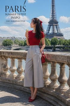 Woman in a red top and wide leg pants holding ice cream in front of the Eiffel Tower
