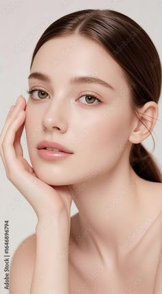 Woman with brown hair and natural makeup posing with a hand on her chin
