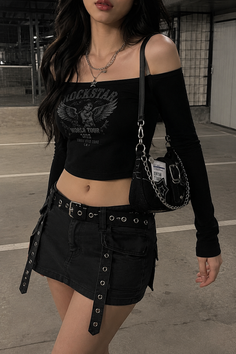Woman in a black crop top and mini skirt with a shoulder bag