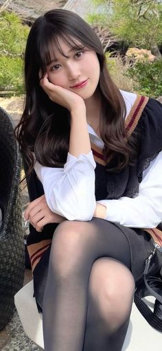 Woman in a school uniform and black tights posing outdoors