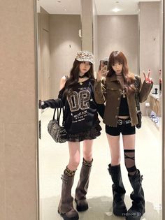 Two women in alternative fashion posing for a mirror selfie indoors