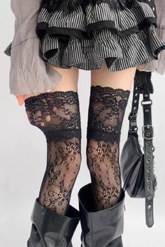 Person wearing a striped ruffled skirt, lace stockings, and black boots