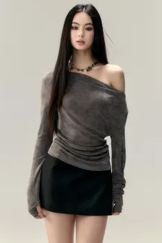 Woman with long black hair wearing an off-shoulder top and mini skirt