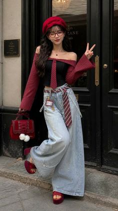 Woman in a red beret and off-shoulder top with wide-leg jeans posing outdoors