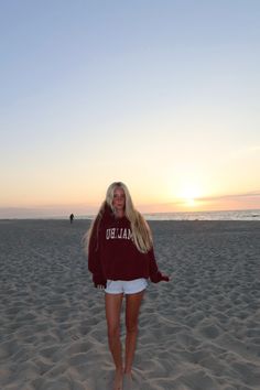 Young woman with long blonde hair on a beach at sunset